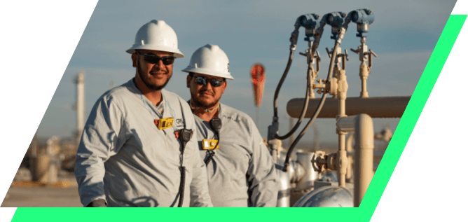 Kinetik employees above a tank farm