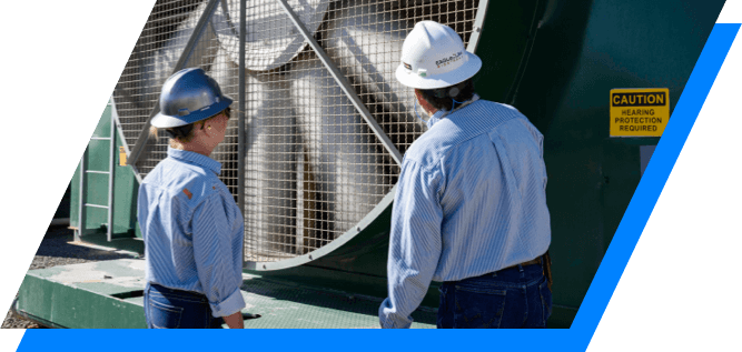 Kinetik employees examining compressors at the West Mustang facility