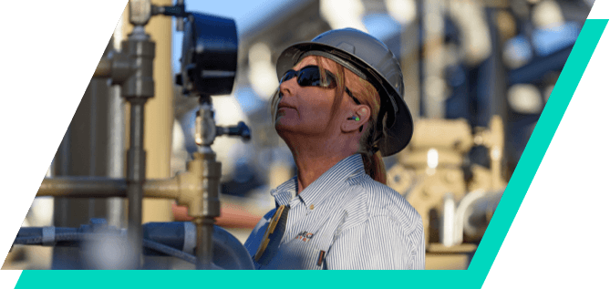 Kinetik employee examining meter at East Toyah plant